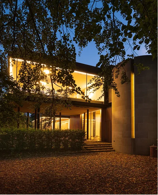 The contemporary retreat building lit at dusk